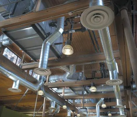 Exposed spiral ductwork and diffusers beneath a timber roof