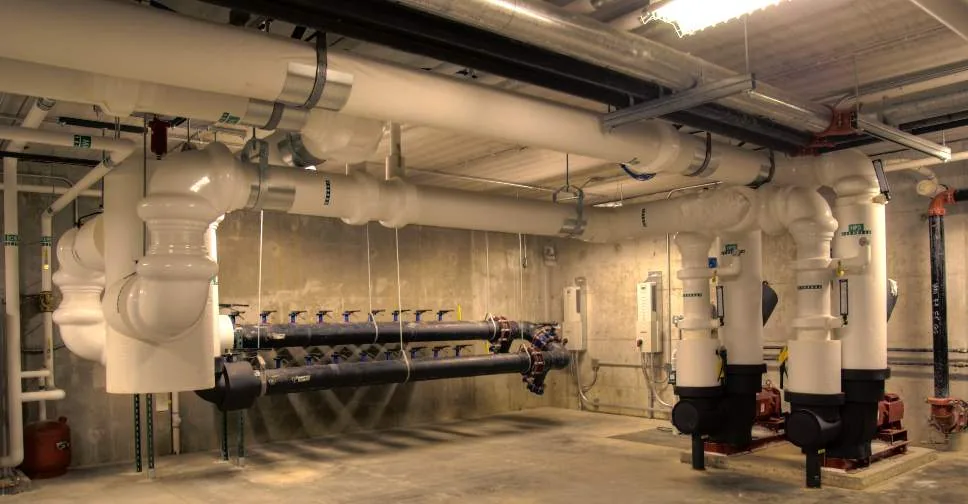 Mechanical room with insulated piping, pumps and a geothermal loop header